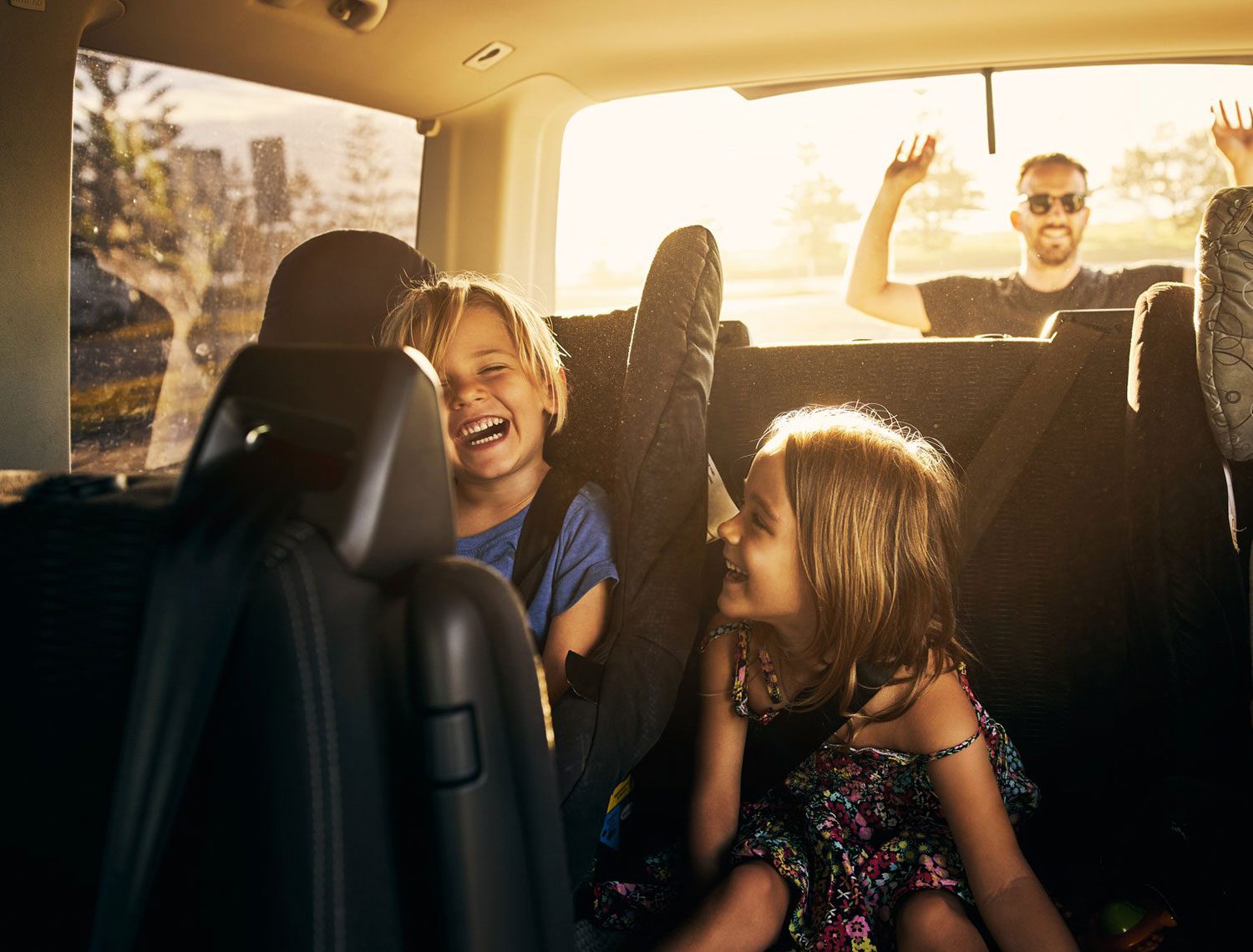 Niños felices con protección solar en el coche